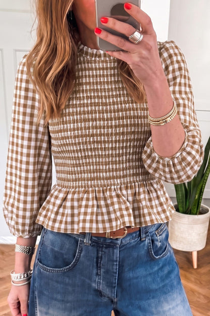 Front view of a taupe and cream gingham smocked peplum top